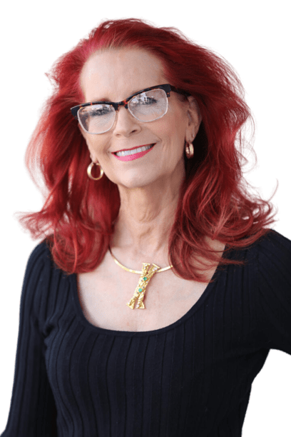 A woman with red hair and glasses is smiling.